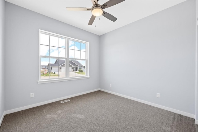 carpeted empty room with ceiling fan and plenty of natural light