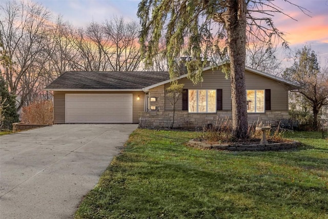 view of front of home with stone siding, concrete driveway, a lawn, and an attached garage