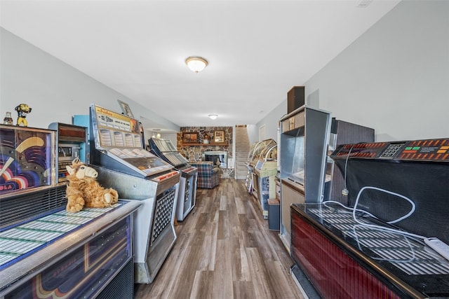 kitchen with open floor plan, a stone fireplace, and wood finished floors