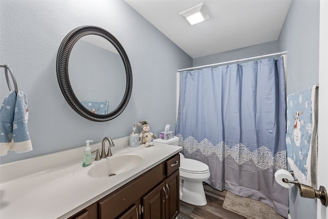 full bathroom featuring toilet, curtained shower, wood finished floors, and vanity