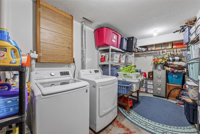 laundry room with laundry area, a textured ceiling, and separate washer and dryer