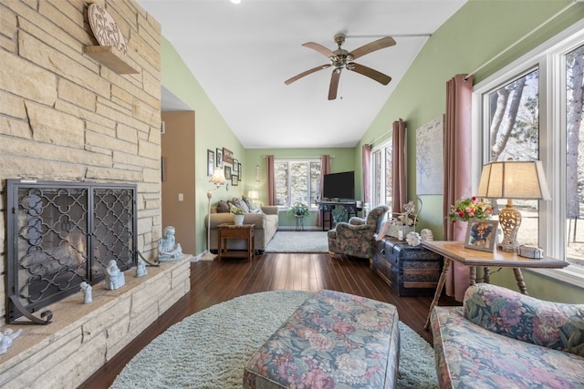 living room featuring wood-type flooring, a fireplace, vaulted ceiling, and a ceiling fan