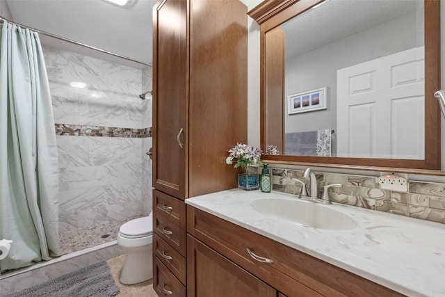 bathroom featuring a stall shower, vanity, toilet, and a textured ceiling