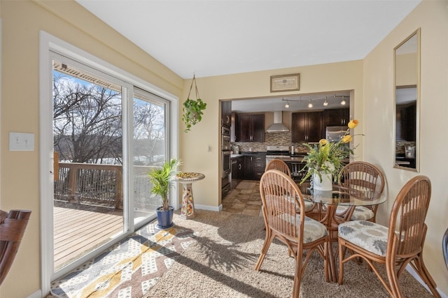 carpeted dining space featuring baseboards