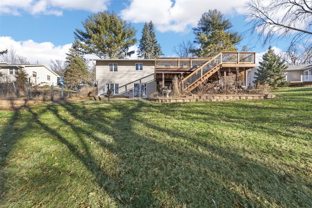 rear view of house with fence, stairway, a lawn, and a wooden deck