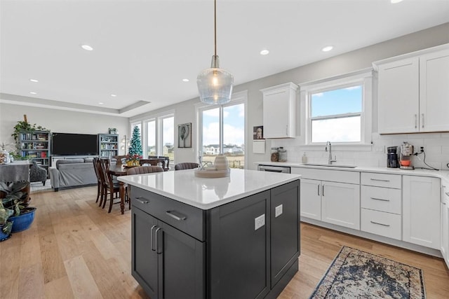 kitchen featuring white cabinetry, plenty of natural light, light wood-type flooring, and sink