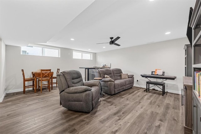 living room with light hardwood / wood-style flooring and ceiling fan