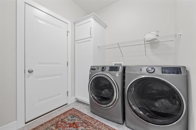 laundry room with washer and dryer and cabinets