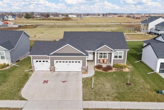 view of front of property featuring covered porch, a garage, and a front yard