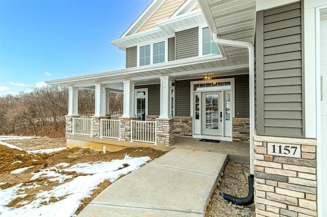 snow covered property entrance featuring a porch