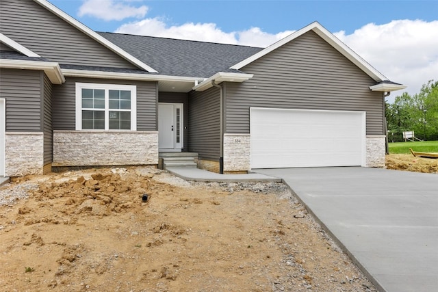 334 Quiver Ct, Marion, IA 52302 - view of front facade featuring entry steps, a garage, stone siding, a shingled roof, and concrete driveway