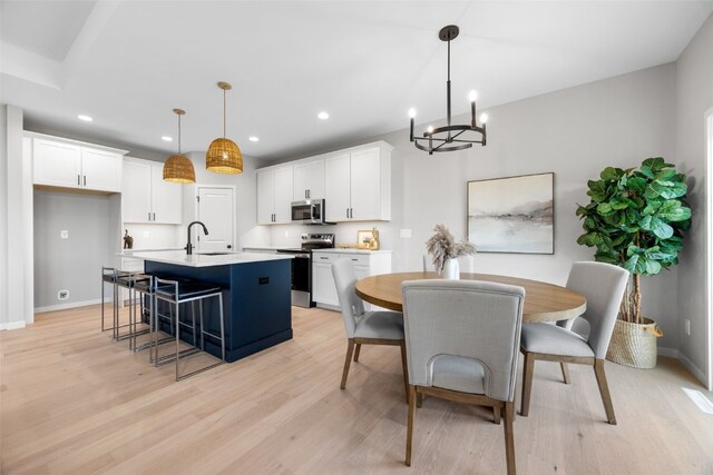 334 Quiver Ct, Marion, IA 52302 - kitchen featuring stainless steel appliances, an island with sink, a chandelier, white cabinetry, and light countertops
