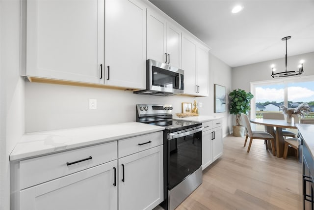 334 Quiver Ct, Marion, IA 52302 - kitchen featuring stainless steel appliances, a chandelier, white cabinetry, light wood-type flooring, and decorative light fixtures