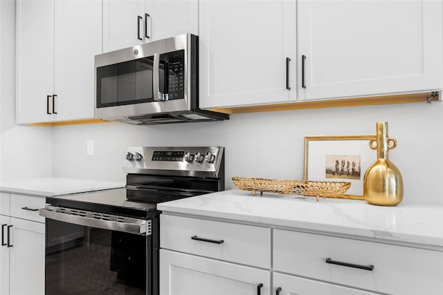 334 Quiver Ct, Marion, IA 52302 - kitchen featuring stainless steel appliances, white cabinets, and light stone counters
