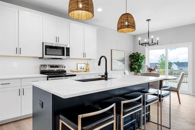 334 Quiver Ct, Marion, IA 52302 - kitchen with appliances with stainless steel finishes, a sink, light wood finished floors, light stone countertops, and white cabinetry