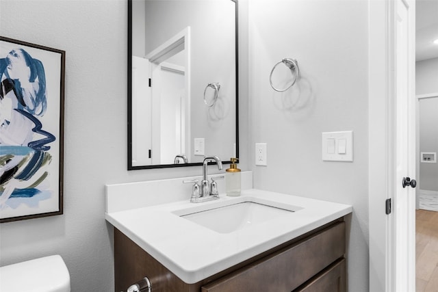 334 Quiver Ct, Marion, IA 52302 - half bathroom with vanity, toilet, and wood finished floors