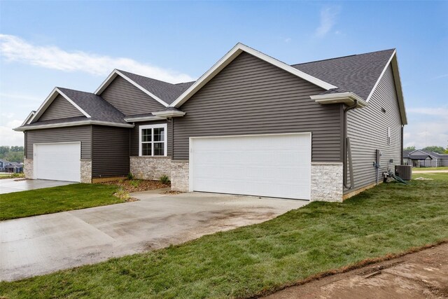 334 Quiver Ct, Marion, IA 52302 - view of front of home featuring central AC, a shingled roof, stone siding, a garage, and a front lawn