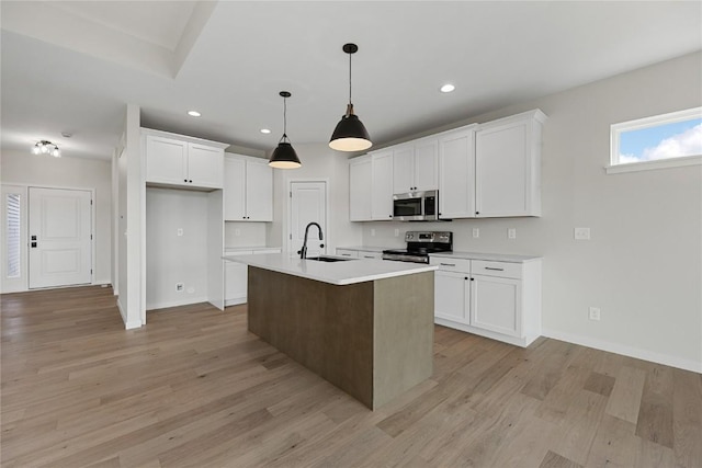 kitchen with sink, white cabinetry, decorative light fixtures, a center island with sink, and appliances with stainless steel finishes