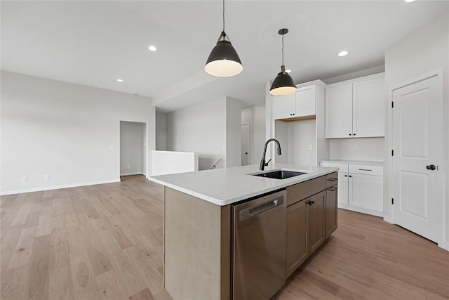 kitchen with pendant lighting, white cabinetry, dishwasher, sink, and a center island with sink