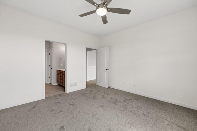 unfurnished bedroom with ensuite bath, light colored carpet, and ceiling fan