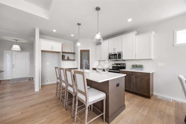 332 Quiver Ct, Marion, IA 52302 - kitchen featuring appliances with stainless steel finishes, a breakfast bar area, light wood-type flooring, white cabinets, and recessed lighting