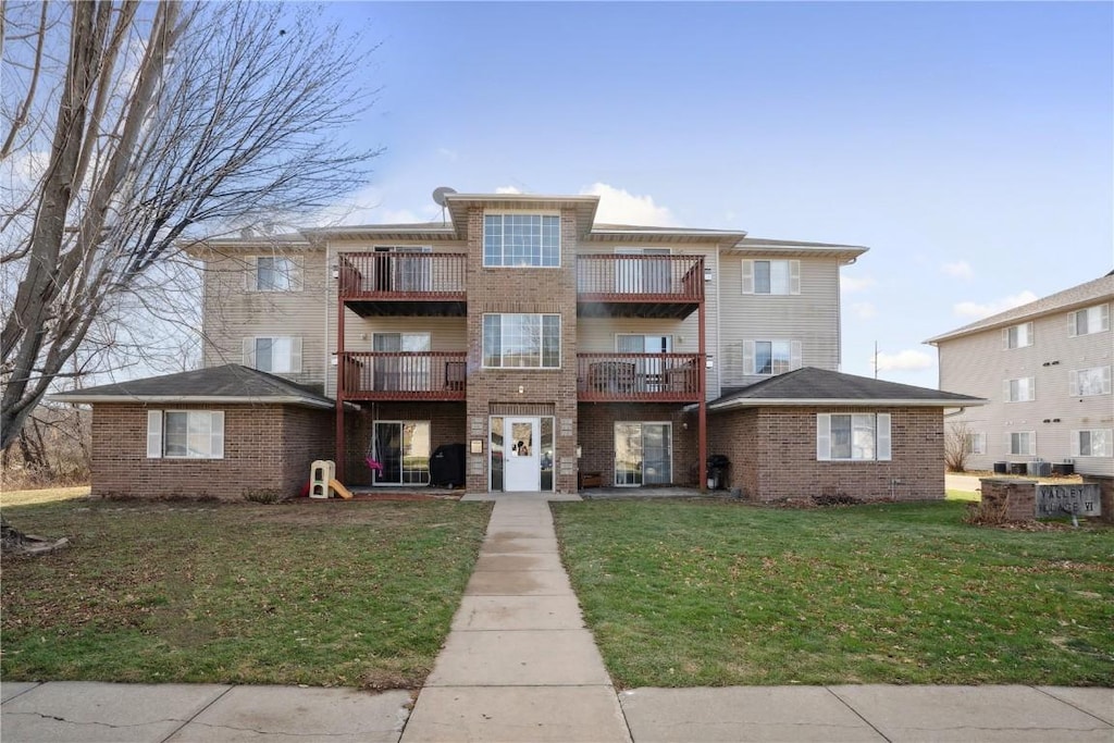 view of front of property featuring a balcony and a front lawn