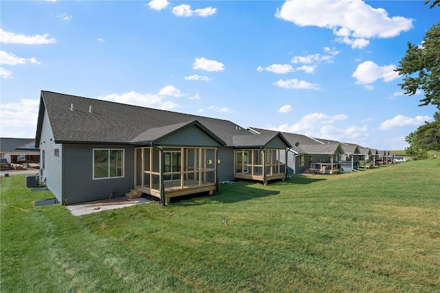 back of house featuring roof with shingles, a yard, a sunroom, cooling unit, and a wooden deck