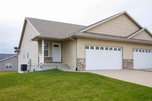 view of front facade with central AC, a garage, and a front lawn