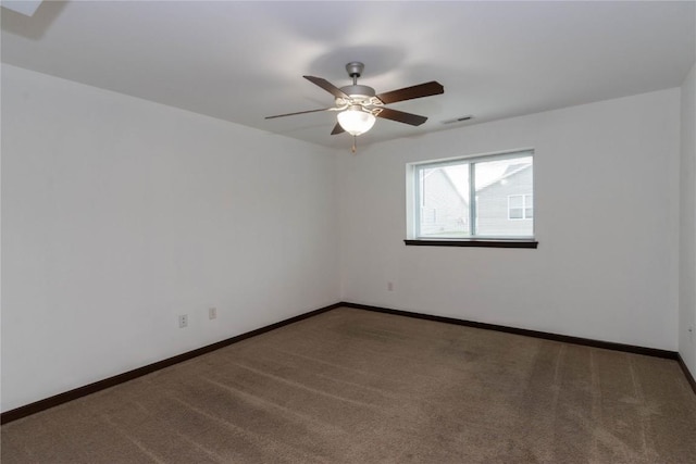 spare room with ceiling fan and dark carpet