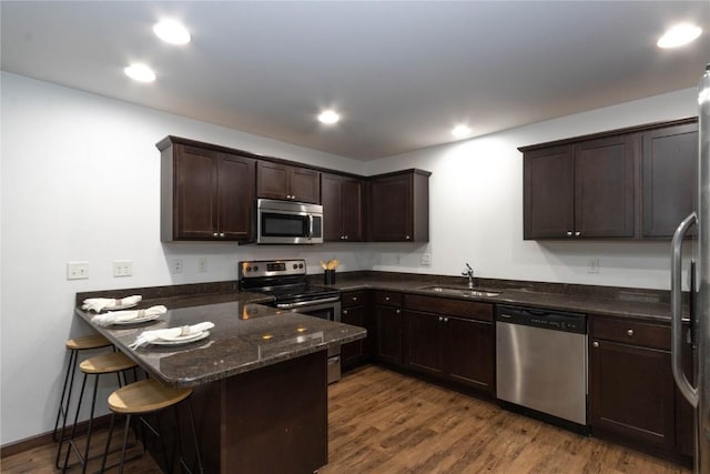 1135 Redbud Ave, Tiffin, IA 52340 - kitchen featuring stainless steel appliances, a sink, dark brown cabinetry, a peninsula, and a kitchen bar