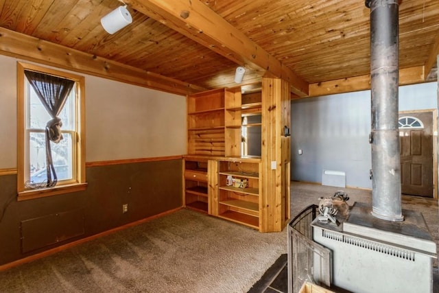 carpeted empty room featuring beamed ceiling and wooden ceiling