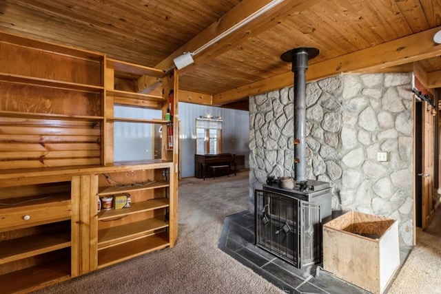 living room with dark carpet, beam ceiling, a wood stove, and wooden ceiling