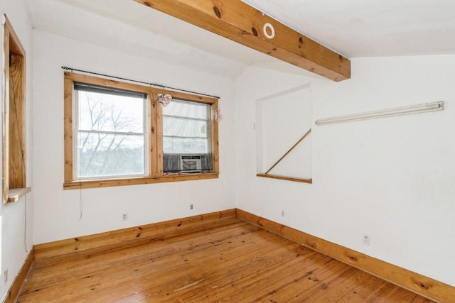 spare room with vaulted ceiling with beams, cooling unit, and wood-type flooring