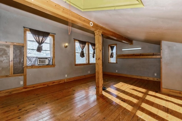 bonus room featuring lofted ceiling with beams, light hardwood / wood-style floors, and cooling unit