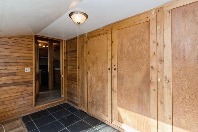 interior space featuring lofted ceiling and wooden walls