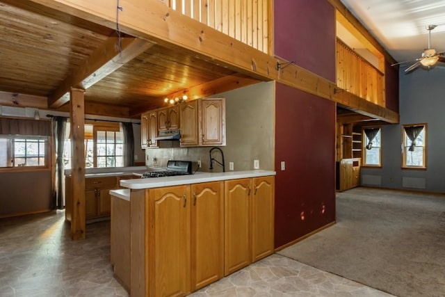 kitchen featuring ceiling fan, black stove, kitchen peninsula, light carpet, and wood ceiling