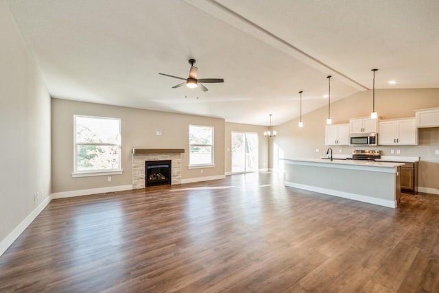 1807 Shady Grove Rd SW, Cedar Rapids, IA 52404 - unfurnished living room with ceiling fan, dark wood finished floors, lofted ceiling, baseboards, and a glass covered fireplace