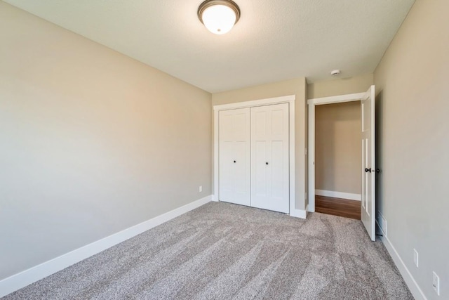 unfurnished bedroom featuring carpet, a closet, and baseboards