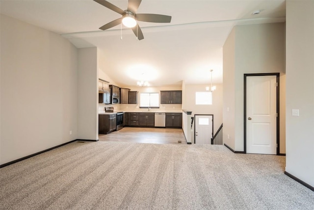 unfurnished living room with light carpet, high vaulted ceiling, and ceiling fan with notable chandelier