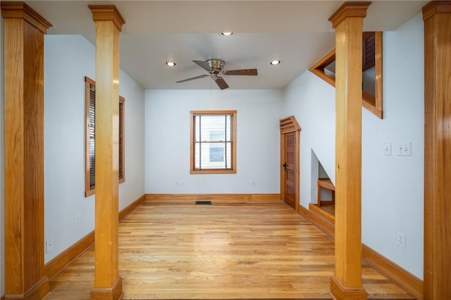 unfurnished living room featuring decorative columns, light hardwood / wood-style floors, and ceiling fan