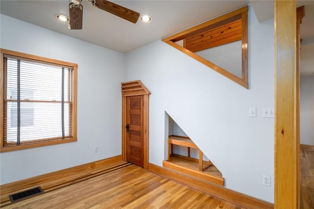 unfurnished living room featuring ceiling fan and light hardwood / wood-style flooring