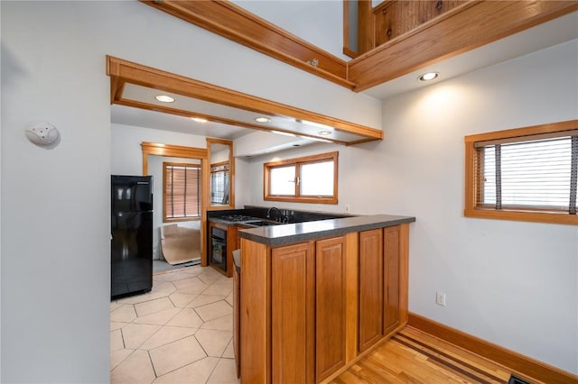 kitchen featuring kitchen peninsula, sink, and black appliances