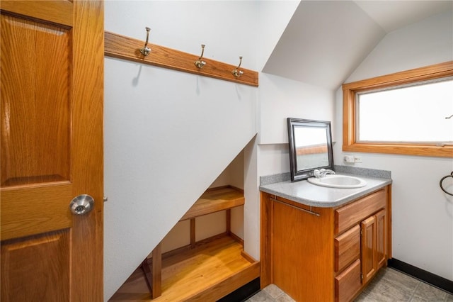 bathroom featuring vanity and lofted ceiling