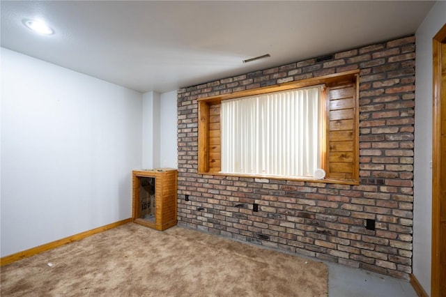 unfurnished living room with brick wall and light carpet