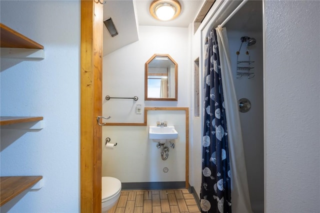 bathroom featuring hardwood / wood-style flooring, walk in shower, toilet, and sink