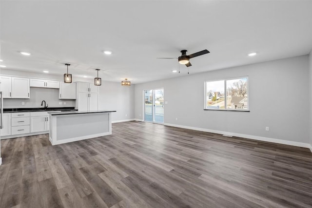 kitchen with pendant lighting, hardwood / wood-style floors, a center island, white cabinets, and ceiling fan