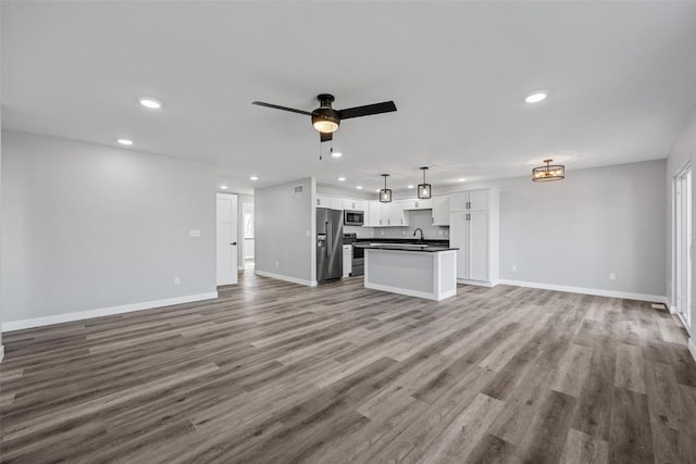 unfurnished living room featuring ceiling fan, sink, and light hardwood / wood-style floors