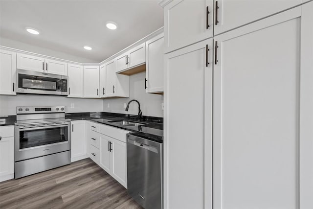 kitchen featuring white cabinetry, sink, stainless steel appliances, and hardwood / wood-style flooring