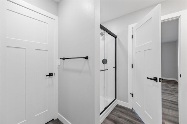 bathroom with hardwood / wood-style floors and an enclosed shower