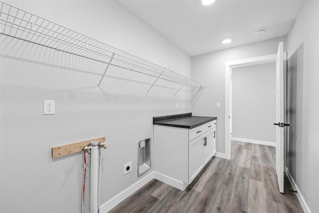 laundry area with electric dryer hookup, cabinets, hookup for a washing machine, and dark wood-type flooring